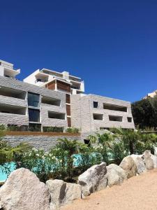 un bâtiment avec des rochers devant un bâtiment dans l'établissement Grand Studio moderne tout confort, à Porto-Vecchio