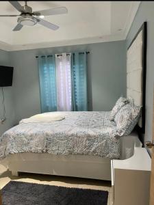 a bedroom with a bed with blue shuttered windows at The Cameron @ Phoenix Park in Portmore