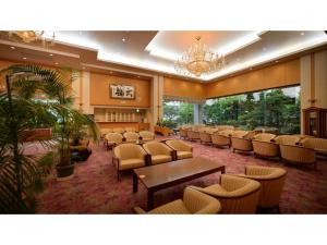 una grande sala d'attesa con sedie e tavoli e un lampadario a braccio di Tendo Grand Hotel Maizuruso - Vacation STAY 36011v a Tendo