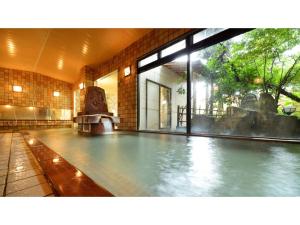 einen Pool in einem Gebäude mit einem großen Fenster in der Unterkunft Tendo Grand Hotel Maizuruso - Vacation STAY 36011v in Tendō
