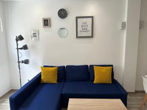 eine blaue Couch in einem Wohnzimmer mit einer Uhr in der Unterkunft Apartamento Miguel Moreno Masson in Málaga