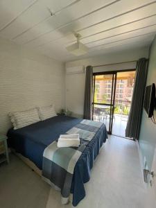 une chambre avec un lit bleu et un balcon dans l'établissement Angra dos Reis - Apartamentos com Vista para o mar OU para piscina Condomínio Porto Bali, à Angra dos Reis 65 autres photos