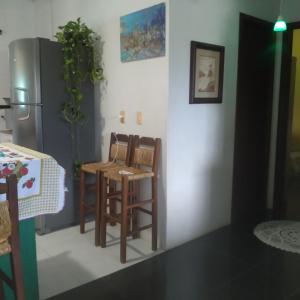 uma cozinha com 2 cadeiras e um frigorífico em Hospedagem no Sul de Florianópolis em Florianópolis