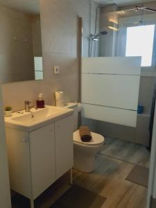 a bathroom with a sink and a toilet and a mirror at Loft espectacular vista al mar in Sitges