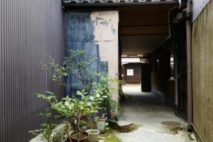 un callejón con una puerta azul y algunas plantas en Honmachi Shin North - Vacation STAY 37152v en Kyoto