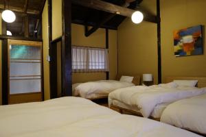 un grupo de 3 camas en una habitación en Honmachi Shin North - Vacation STAY 37152v en Kyoto