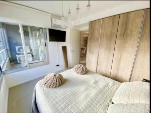 een slaapkamer met een bed met 2 kussens erop bij Hermoso apto en Edificio Gala Puerto in Punta del Este