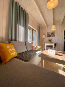 un soggiorno con un divano e un tavolo di Domki Poezja Ciszy a Dębki