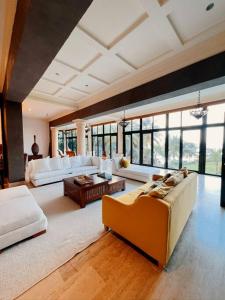 una gran sala de estar con muebles y ventanas blancos. en Tesoros del Mar en Santa Cruz de Barahona