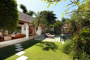 a backyard with a swimming pool and a house at Villa Bali Asri in Seminyak