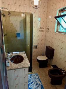 uma casa de banho com um lavatório, um WC e um chuveiro em Sítio Mato Dentro em Atibaia