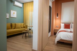 um quarto com uma cama e um sofá num quarto em White Luxury Apartments em Kateríni