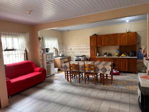 インベーにあるCasa albatroz Imbéの赤いソファとテーブル付きのキッチンが備わります。