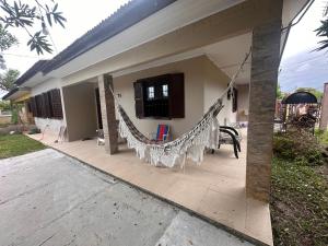 a house with a hammock outside of it at Casa albatroz Imbé in Imbé