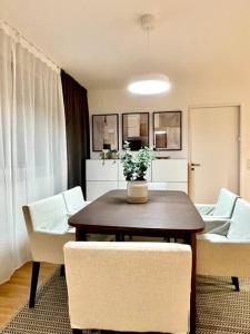 ein Wohnzimmer mit einem Tisch und weißen Stühlen in der Unterkunft Modern Urban Retreat in Pratteln