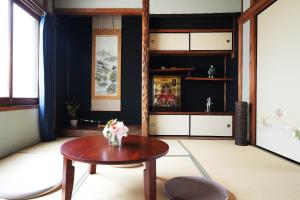 uma sala de estar com uma mesa de madeira e um vaso de flores em Kyoka no Yado - Vacation STAY 40559v em Quioto