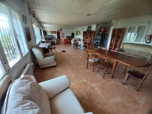 sala de estar con sofá, mesa y sillas en Cortijo la Umbria, en Villanueva de Algaidas