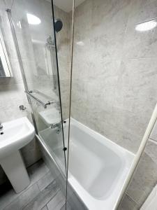 La salle de bains est pourvue d'une douche, d'une baignoire et d'un lavabo. dans l'établissement Camden Apartment, à Londres