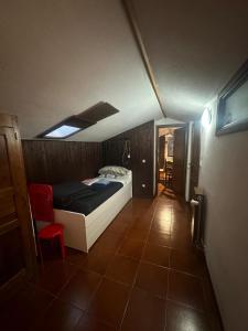 Appartamento di montagna في مورجيكس: غرفة نوم صغيرة مع سرير في غرفة ذات سقف