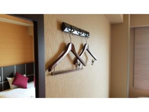 2 appendiabiti appesi a un muro in una camera da letto di My Hotel Okazaki - Vacation STAY 40799v a Okazaki