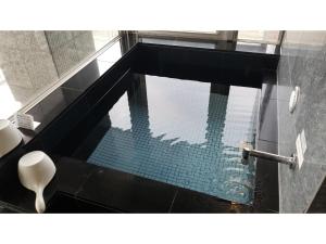 piscina in bagno con pavimento nero di My Hotel Okazaki - Vacation STAY 40799v a Okazaki