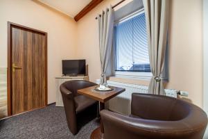 une chambre avec une table, des chaises et une fenêtre dans l'établissement LAGUNA Hotel & Restaurant, à Přimda