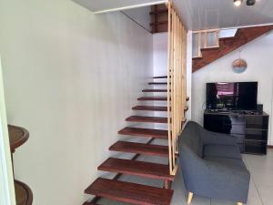 モーレア島にあるMaison Moehau Itiのソファと椅子付きの客室内の階段
