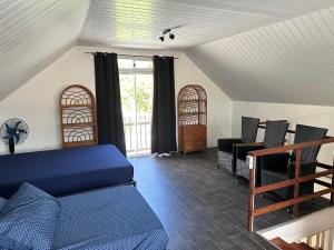 a living room with a blue couch and chairs at Maison Moehau Iti in Moorea