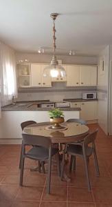 a kitchen with a table and some chairs and a table and a kitchen at Ca La Silvia Masboquera in Mas Boquera