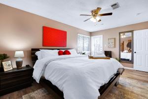 sypialnia z dużym białym łóżkiem z czerwonymi poduszkami w obiekcie Pong - A Birdy Vacation Rental w mieście San Antonio
