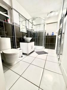 a white bathroom with a toilet and a shower at Lime Tree House in Heston