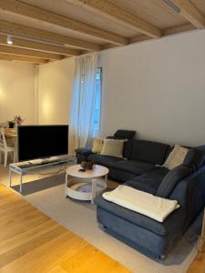 uma sala de estar com um sofá azul e uma mesa em Your Cozy City Bungalow em Baden