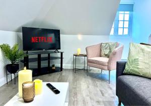 a living room with a tv and two chairs at Month-long availability, Beautiful flat 2min walk to station, with parking in Borehamwood