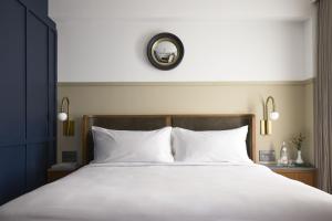 Un pat sau paturi într-o cameră la Hotel Heron
