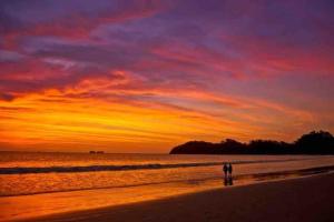 a person walking on the beach at sunset at Nirvana Beach Home in Paraíso