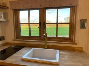 a kitchen with a sink in front of a window at Luxury Shepherd Hut in Kelham