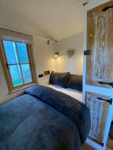 a bedroom with a bed and a couch and a window at Luxury Shepherd Hut in Kelham