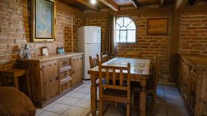 a kitchen with a table and a refrigerator at Hotel Real de San Antonio in Estanzuela