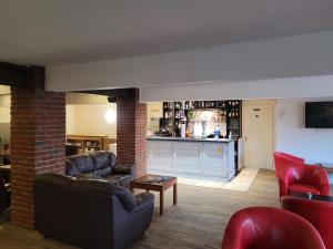 a living room with couches and a bar at The White Horse Lodge Hotel in Thirsk