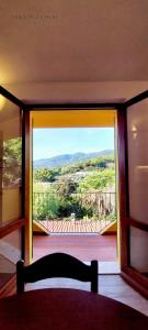 a room with a door open to a balcony with a view at Villa del Colle Charme e Relax in Procchio