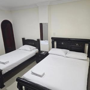 - 2 lits dans une chambre avec des draps blancs dans l'établissement Hotel Barranquilla Inn, à Barranquilla