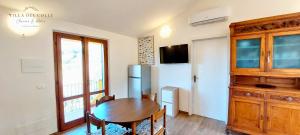 a dining room with a table and a refrigerator at Villa del Colle Charme e Relax in Procchio