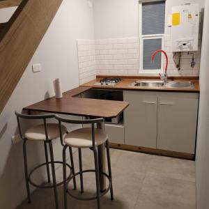 cocina con mesa de madera y 2 taburetes en Apartamento Estocolmo III, en Valdivia