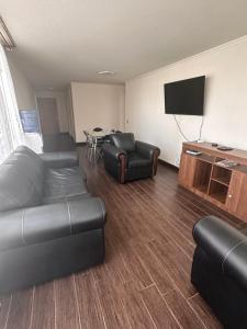 a living room with a couch and a flat screen tv at Departamento con vista al mar in Iquique