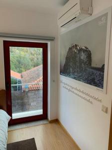 Cette chambre dispose d'une porte avec une photo sur le mur. dans l'établissement Casa da Carvalha - Loriga, à Loriga