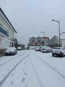 a street covered in snow with cars parked at Casa da Carvalha - Loriga in Loriga