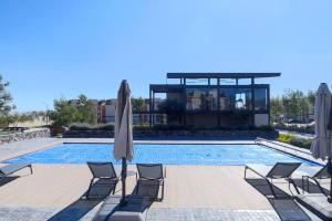 une piscine avec des chaises et un parasol ainsi qu'une maison dans l'établissement Increíble Apartamento Querétaro, à Querétaro
