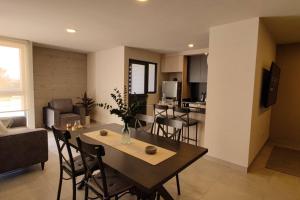 Il comprend une cuisine et un salon avec une table et des chaises. dans l'établissement Increíble Apartamento Querétaro, à Querétaro