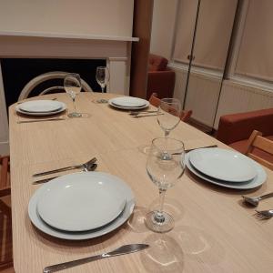 a table with white plates and wine glasses on it at Flat in London King’s Cross in London