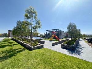 un parc avec une aire de jeux et un toboggan dans l'établissement Increíble Apartamento Querétaro, à Querétaro